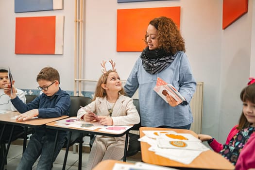 Female teacher helping elementary students at language school class.