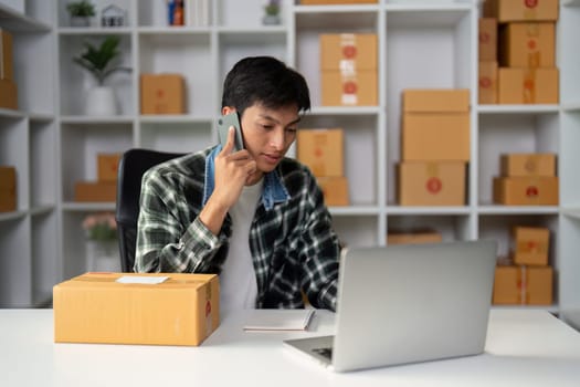 A young professional handles customer calls and manages orders, showcasing multitasking skills in a modern office setting.