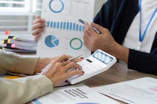Professionals analyze financial reports and data collaboratively, using calculators and charts to enhance their insights.