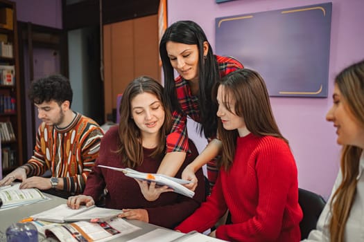 Female teacher explaining subject to her teenage students at language school.