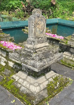 Ancient ancestors javanese king and queen burial in remote jawa, Indonesia, traditional moss-covered stone graves decorated with pink flower petals, depicting respect and cultural heritage in a serene environment surrounded by greenery