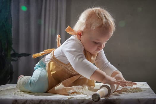 A girl explores the texture of flour while playing in a studio, showcasing a fun and creative cooking activity.