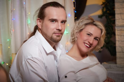 A joyful couple basks in festive decorations, embracing the holiday spirit during Christmas and New Year celebrations.