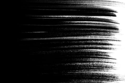 Irregular black brush strokes as a gradient on a white background.