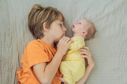A young boy and his newborn brother lie together on a soft muslin blanket, sharing a tender sibling moment. A heartwarming scene of brotherly love, bonding, and the beginning of a lifelong connection.