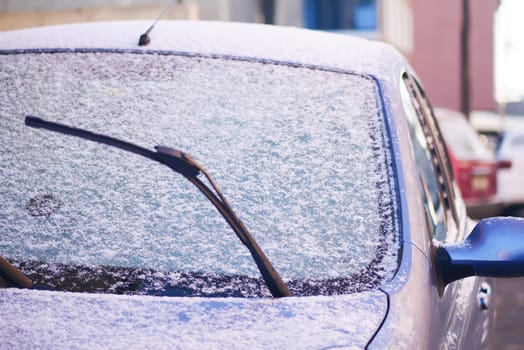 Fresh snow blankets parked cars in an urban area during winter.
