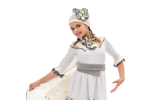 A girl in a detailed white costume dances gracefully, showcasing traditional attire at a cultural event during the festive season.