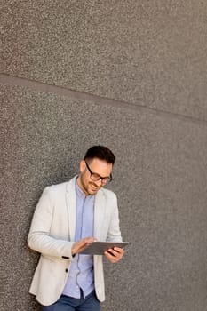 Portrait of a young businessman holding digital tablet outdoor in urban enviroment