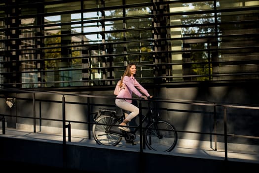 Young woman riding e bike in urban enviroment at sunny day
