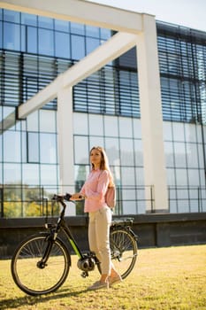 Pretty young woman with modern city electric e-bike clean sustainable urban transportation