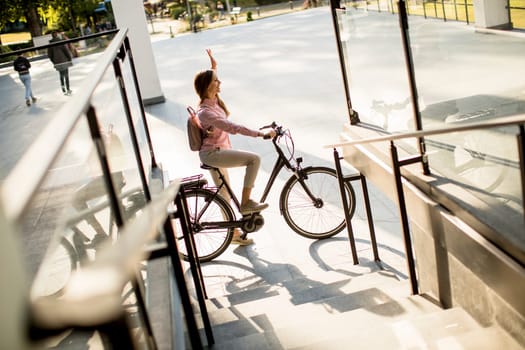 Young woman riding e bike in urban enviroment at sunny day