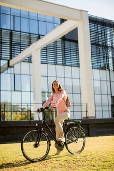 Young woman riding e bike in urban enviroment at sunny day
