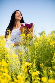 Pretty young woman in the rapeseed field