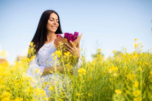 Pretty young woman in the rapeseed field