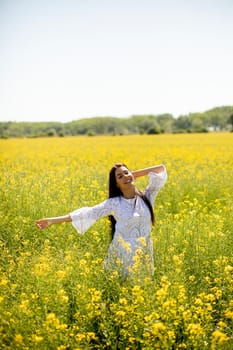 Pretty young woman in the rapeseed field