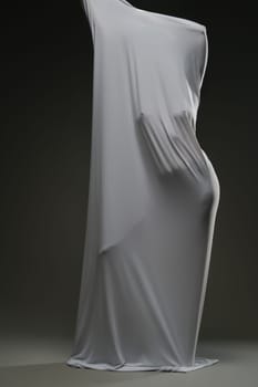 A woman poses gracefully, her beauty accentuated by soft draping fabric that highlights her figure.
