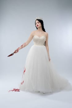 A woman dressed as a bride stands confidently, holding a knife with blood dripping, challenging traditional beauty.