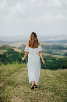Back view at young  woman relaxing outside in nature at summer day