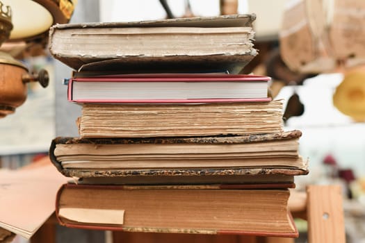 Stack of worn tattered antique books in a vintage store