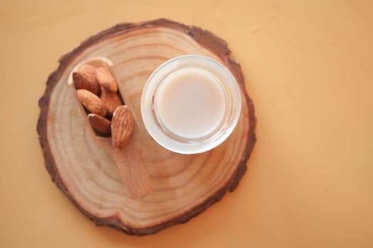 Creamy almond milk served in a glass with whole almonds nearby.