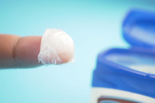 Applying petroleum jelly or moisturizer to hands.