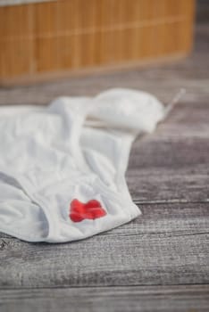 White underwear with period stain on wooden table.
