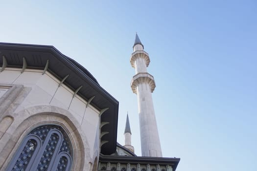 Stunning minarets reach towards the bright sky near the mosque.