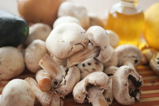 Fresh white mushrooms with vegetables and oil ready for a meal preparation.