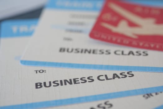 Business class tickets and travel documents displayed on a table.
