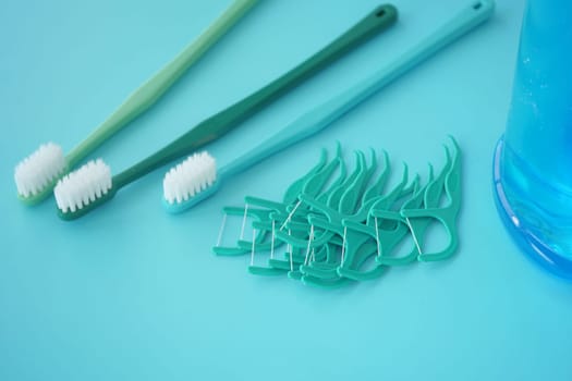Various toothbrushes and dental floss picks laid out neatly.