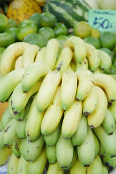 Bunches of green and yellow bananas for sale at a lively market stall.
