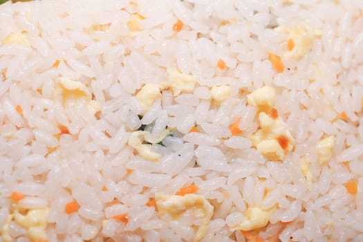A colorful dish of fried rice featuring vegetables and egg pieces.