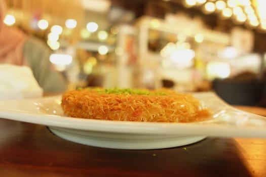 Delicious turkish kunefe dessert on a table .