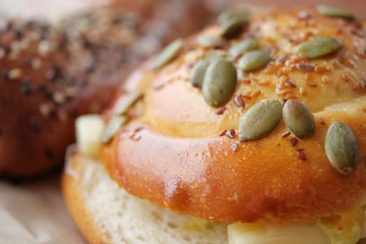 Delicious baked bread rolls topped with seeds in a warm bakery.