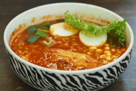 A rich, flavorful soup features noodles, greens, and soft-boiled eggs.