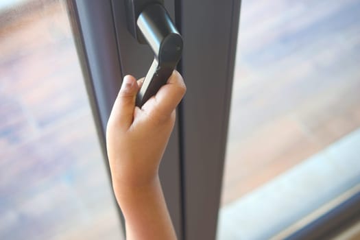 A child reaches for a door handle, eager to enter the room.