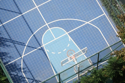 Overhead view of a vibrant basketball court on a sunny day.