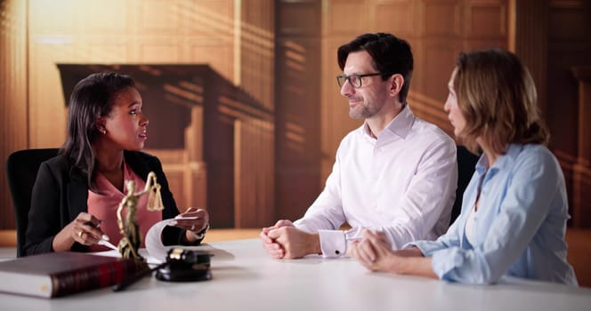 Diverse Couple Meeting with Family Lawyer for Financial Counseling Session.
