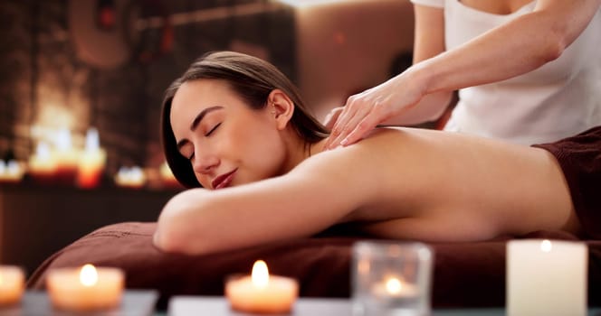 Relaxed young woman getting a shiatsu massage at the spa.
