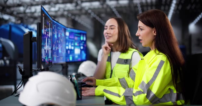 Female engineer monitors control screen at gas power plant facility.