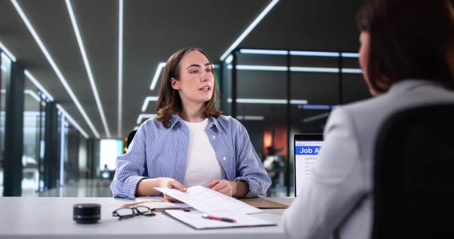 Businesswoman shaking hands with recruiter during consulting interview for staffing.