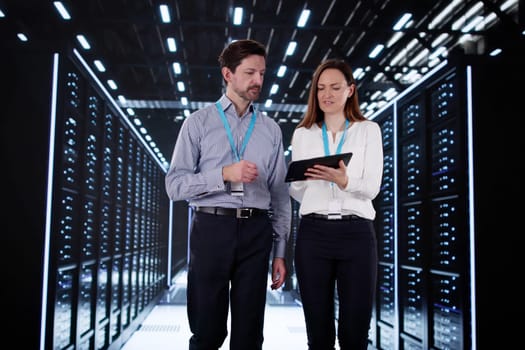 Engineers configuring AI technology in data center server room.