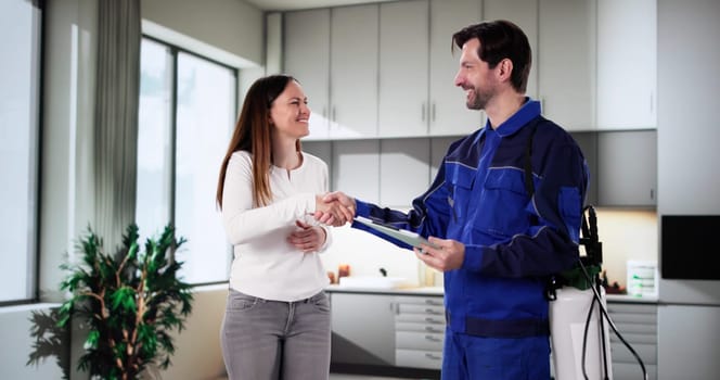 Pest Control Worker Presenting Invoice to Woman in Home Kitchen