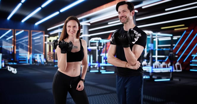 Personal Trainer Helps Mature Couple with Weightlifting in Gym