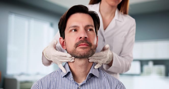 The Doctor carefully palpates the thyroid gland during physical exam