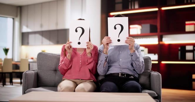 Couple Seeking Answers with Question Mark Held In Front Face.