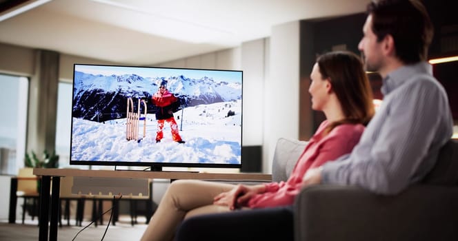 Relaxed couple enjoying movie night in cozy living room at home.