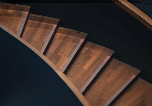 Bangkok, Thailand - Mar 02, 2025 - Layered wood spiral stairs with railings handle grip interior. View of Geometric shape of wooden curved staircase, Interesting architectural elements, use it as your Wallpaper, Poster and Copy space, Selective focus.