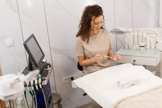 A skilled aesthetician prepares for a beauty treatment in a pristine spa. Soft lighting and sleek equipment enhance the calming atmosphere, showcasing a moment of tranquility and care.