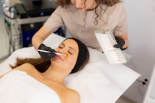 A beauty therapist applies a rejuvenating cream to a client's face, aiming to enhance moisture and reduce wrinkles. The treatment unfolds in a tranquil salon environment.